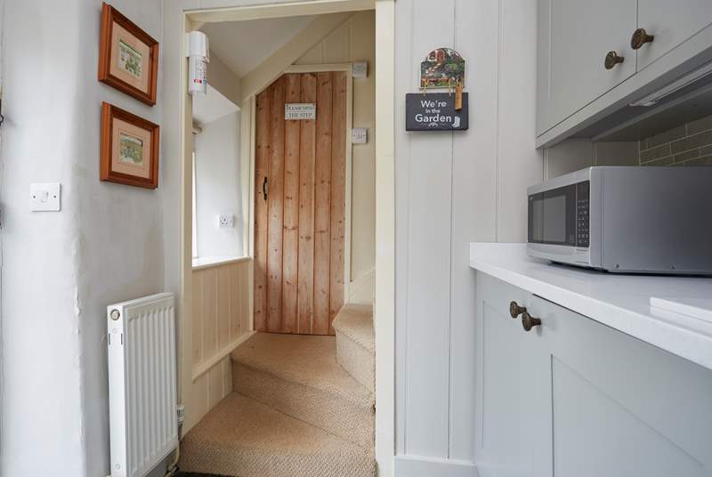 Beyond the kitchen, two steps up to the bathroom and the cottage staircase.