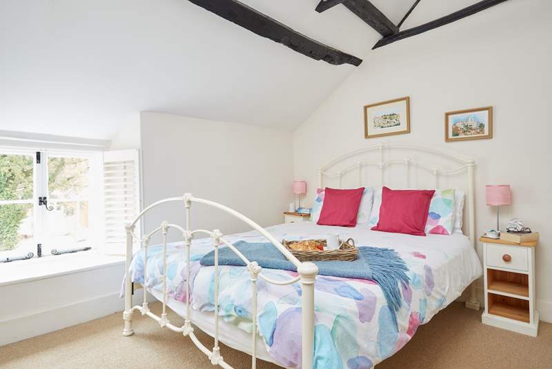 Cool shades in the pretty bedroom, with a window overlooking the courtyard and front of the cottage.