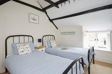 The second bedroom is a comfortable twin in pretty coastal shades.