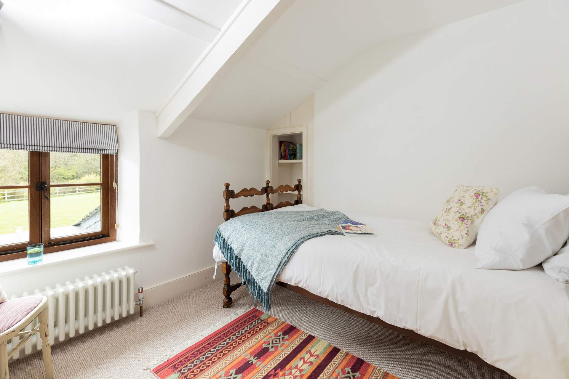 Bedroom two with a three-foot single and view to the back of the cottage.
