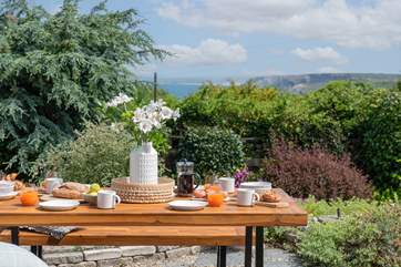 The elevated garden and stepped terrace is bursting with life and has a lovely view of the sea.