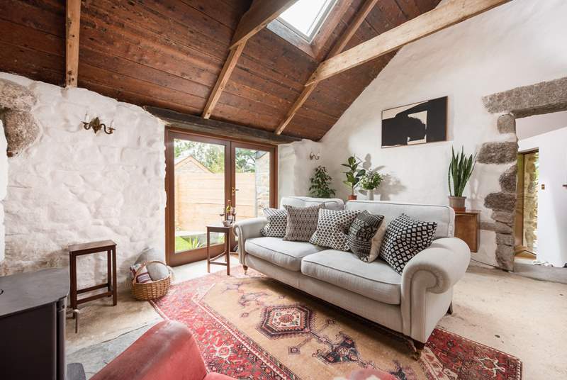 Crooked walls, exposed beams and healthy foliage marry together beautifully to create this lounge space.