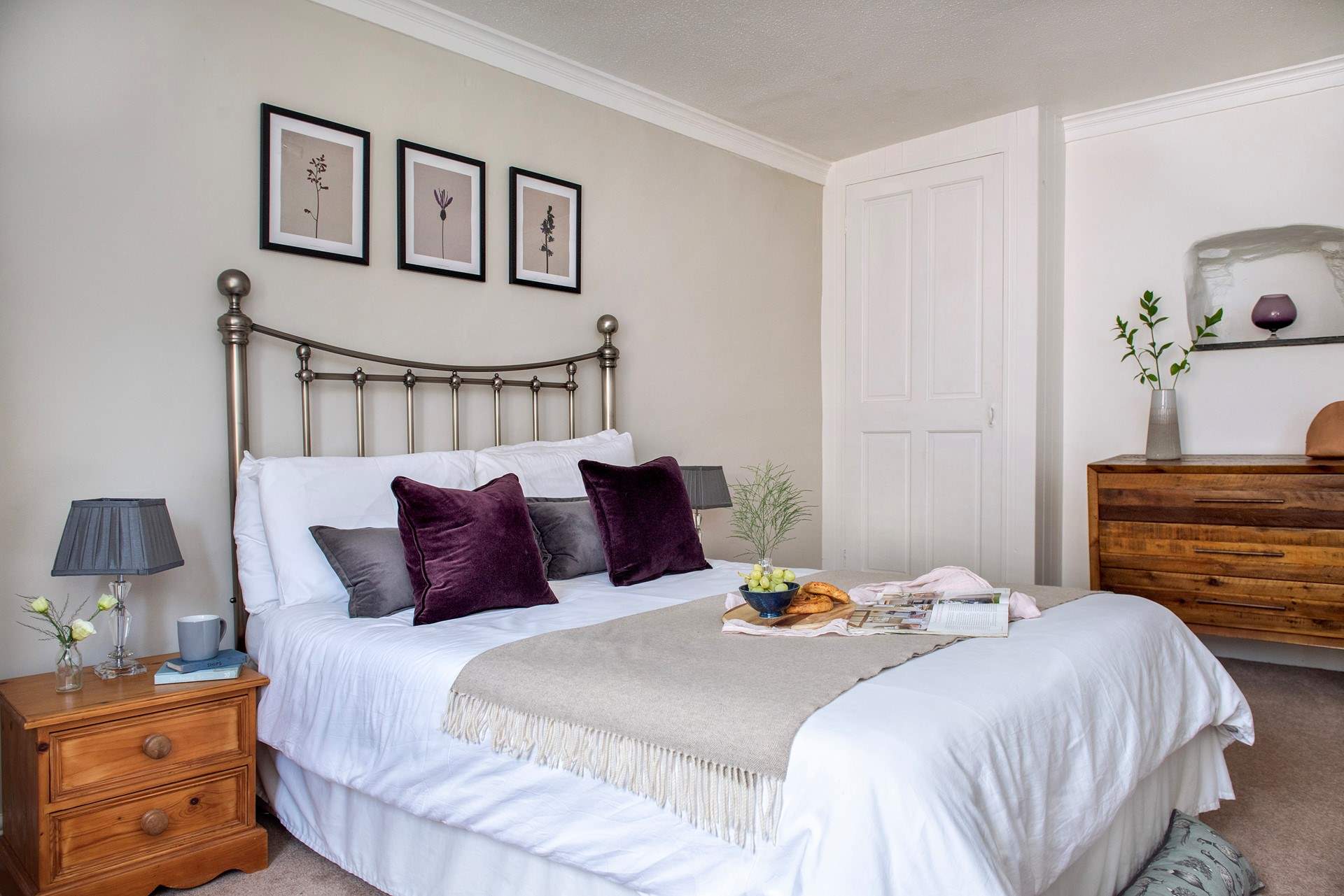 Plump cushions adorn the bed in bedroom 1.