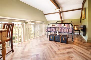A creatively designed mezzanine bedroom with king-size bed on the first floor. You will love looking across the rolling meadows.