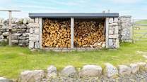 At the rear is the log store and fields of sheep beyond.