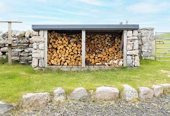 At the rear is the log store and fields of sheep beyond.