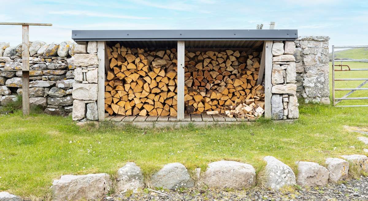 At the rear is the log store and fields of sheep beyond.