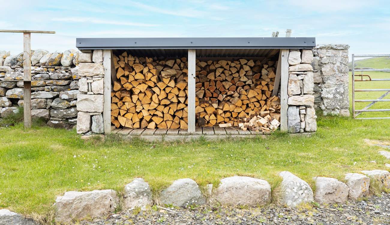 At the rear is the log store and fields of sheep beyond.