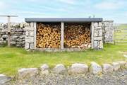 At the rear is the log store and fields of sheep beyond.
