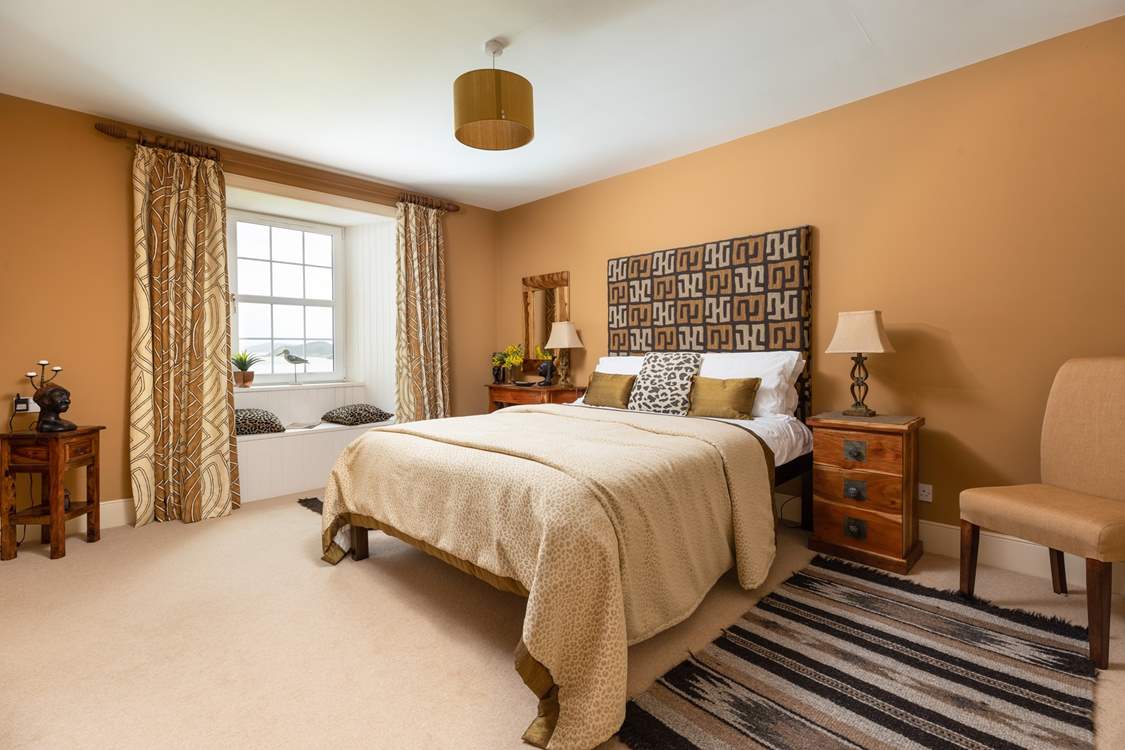 This stylish bedroom has an en suite shower-room and a window seat with views.