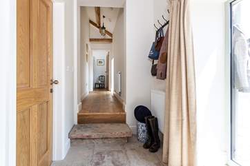 Original stone floors and beams grace the hallway. Please take care on the stone step here.