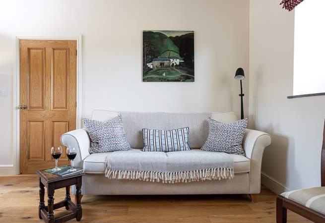 The snug features a comfy sofa and local artwork.