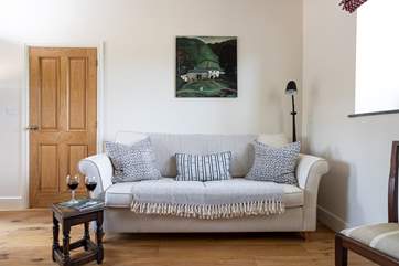 The snug features a comfy sofa and local artwork.