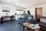 The open plan living area floods with light and benefits from under-floor heating.