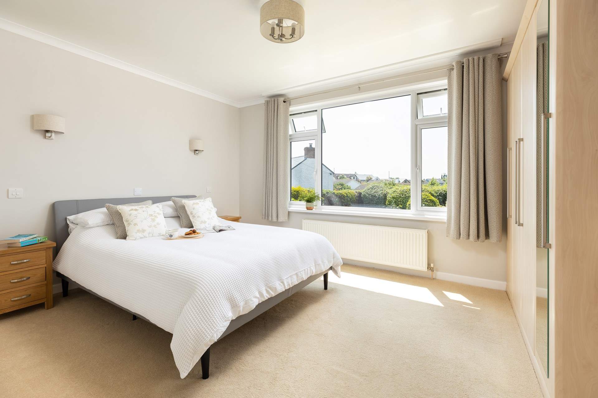 The beautiful and spacious bedroom 1 has a comfy king-size bed, a TV and ample hanging space.