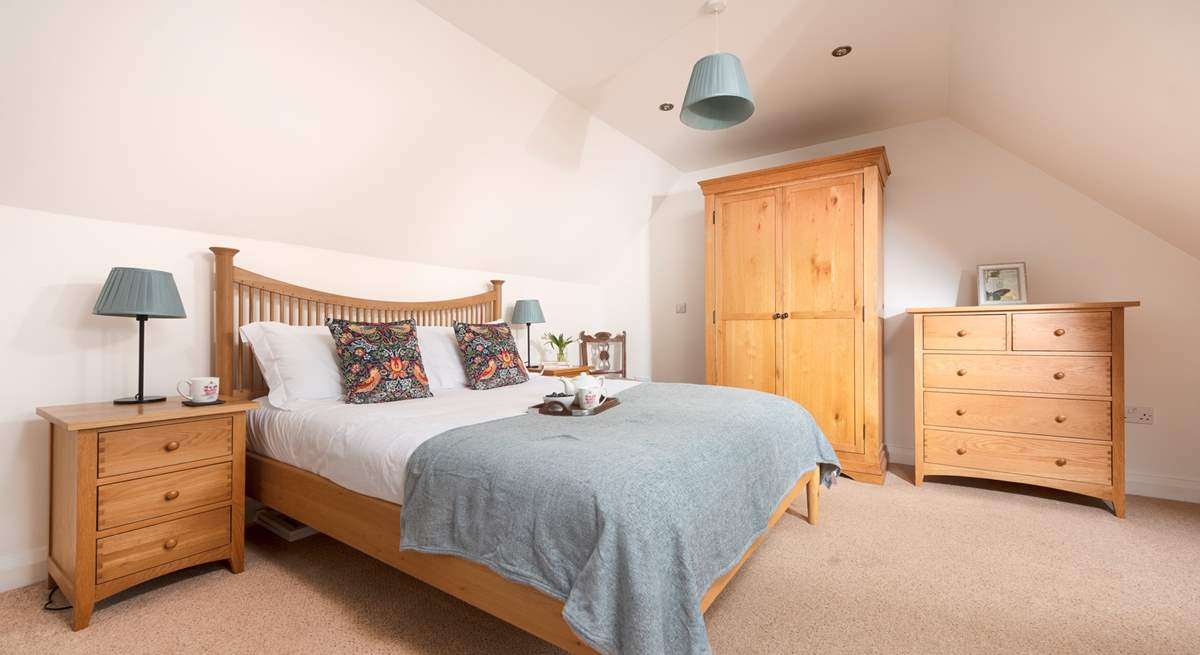 Bedroom 2 on the first floor has a king size bed and calming blue hues. 