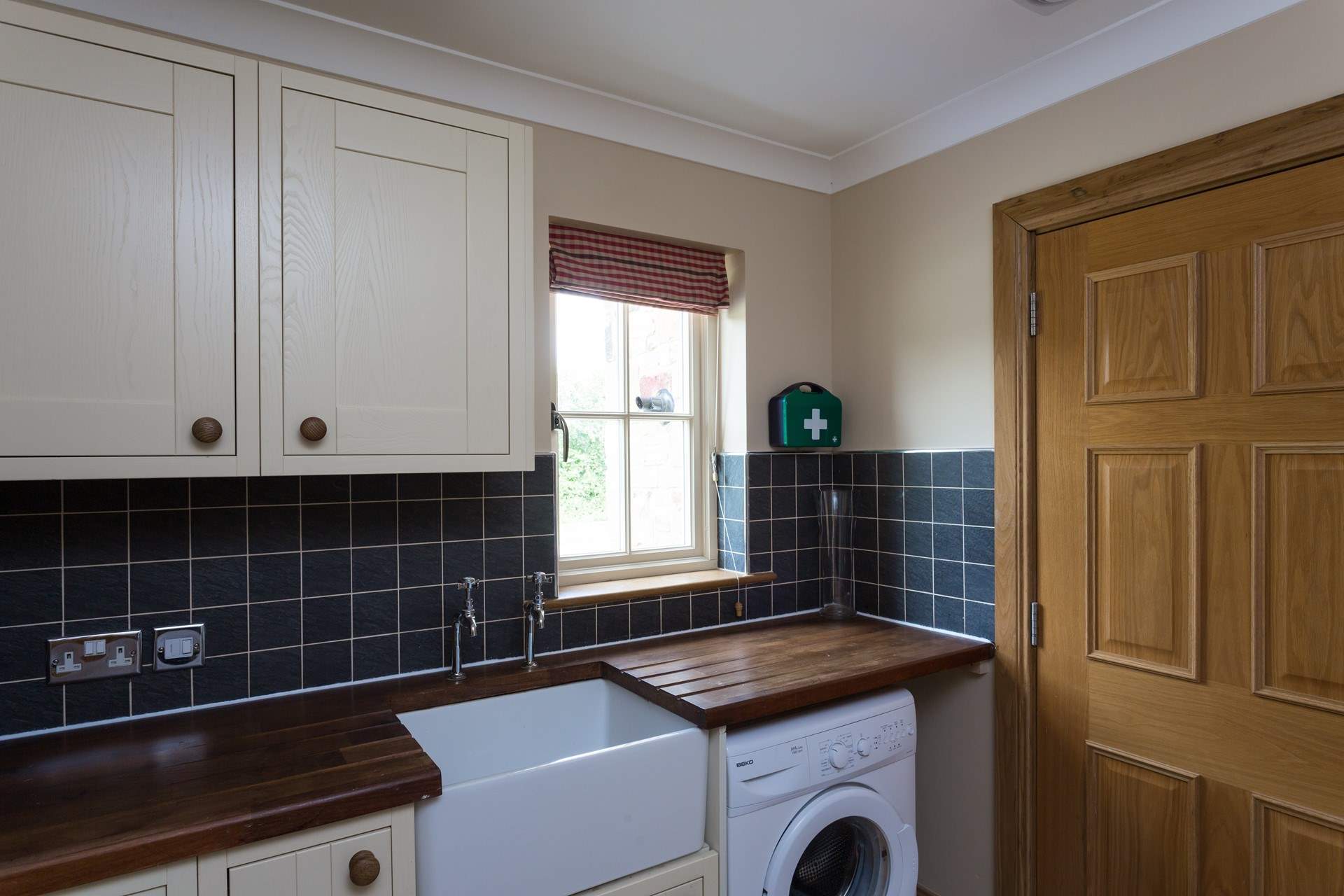 The useful utility-room houses a freezer and washing machine.