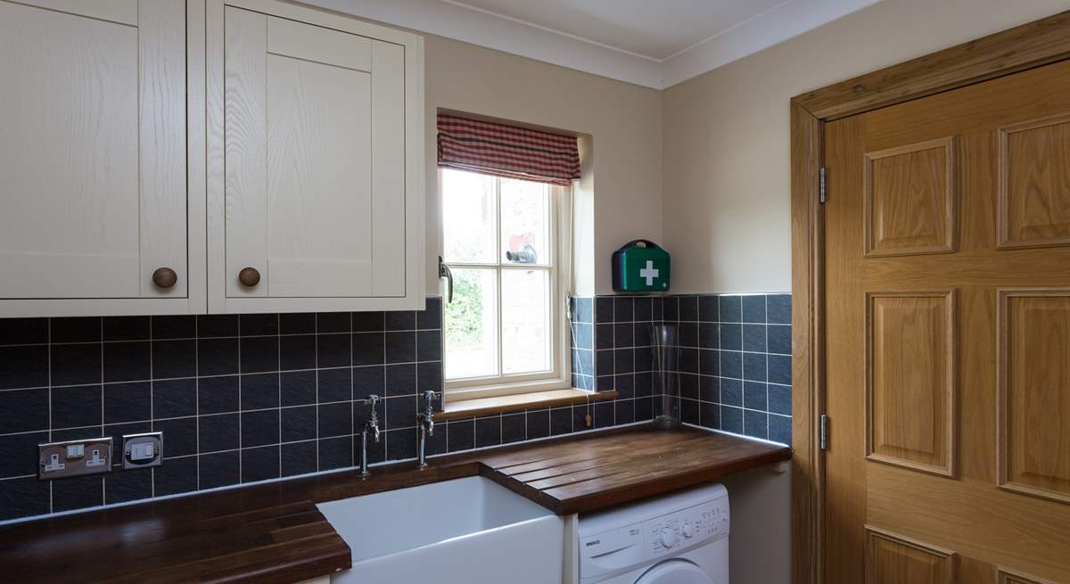 The useful utility-room houses a freezer and washing machine.