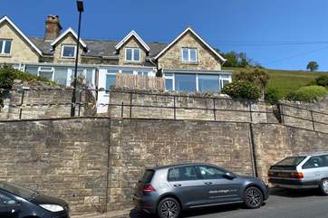 Verbena Cottage sits perched above the road in a row of traditional stone cottages with parking below.(second property from the right)