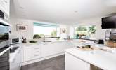 The kitchen window frames the stunning view of the garden, out across the surrounding countryside and the sea beyond. - Thumbnail Image