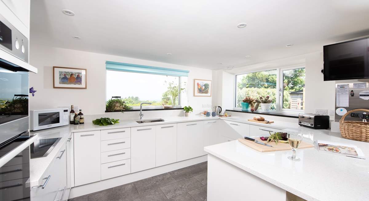 The kitchen window frames the stunning view of the garden, out across the surrounding countryside and the sea beyond.