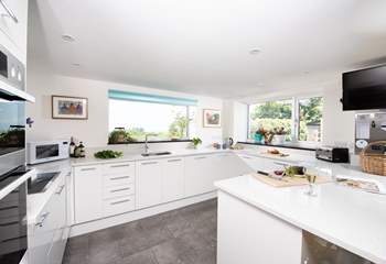 The kitchen window frames the stunning view of the garden, out across the surrounding countryside and the sea beyond.