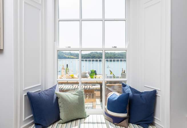 The window seat is perfect for watching boats sail by. 