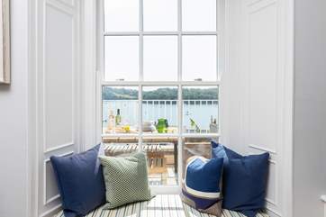 The window seat is perfect for watching boats sail by.