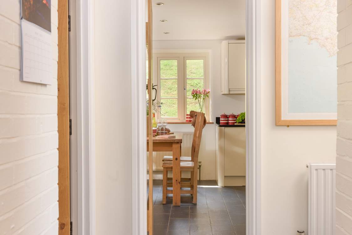 There is a handy cloakroom next to the kitchen. You can see the door slightly ajar (to the left).