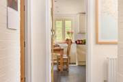There is a handy cloakroom next to the kitchen. You can see the door slightly ajar (to the left).