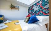 The bedroom hosts a sumptuous double bed with a wild folklore-inspired wall painting by a local artist.  - Thumbnail Image