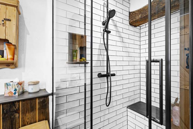 A spacious shower with a handy bench!