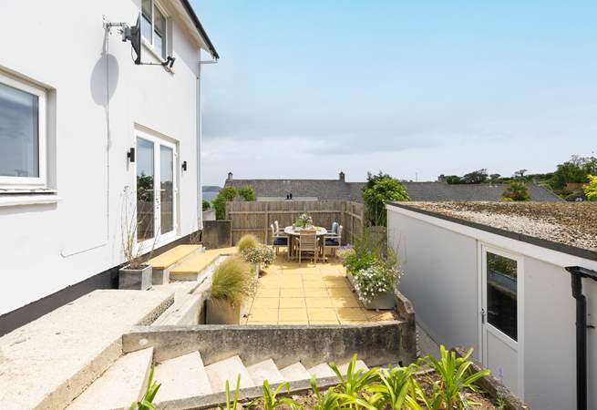 The outside terrace is perfect for dining with friends. Steps lead down to the parking area at the rear of the garage.