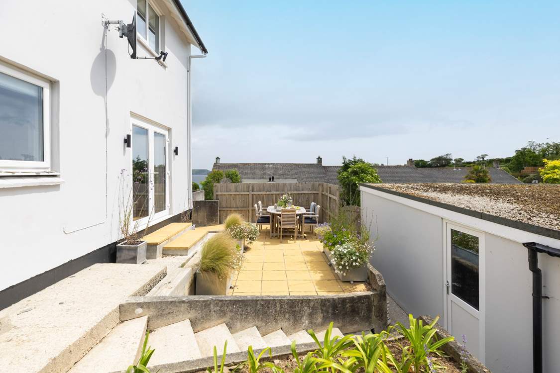 The outside terrace is perfect for dining with friends. Steps lead down to the parking area at the rear of the garage.