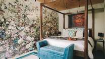 The stunning main bedroom hosts a king-size four-poster bed, adorned with luxurious soft linens. 