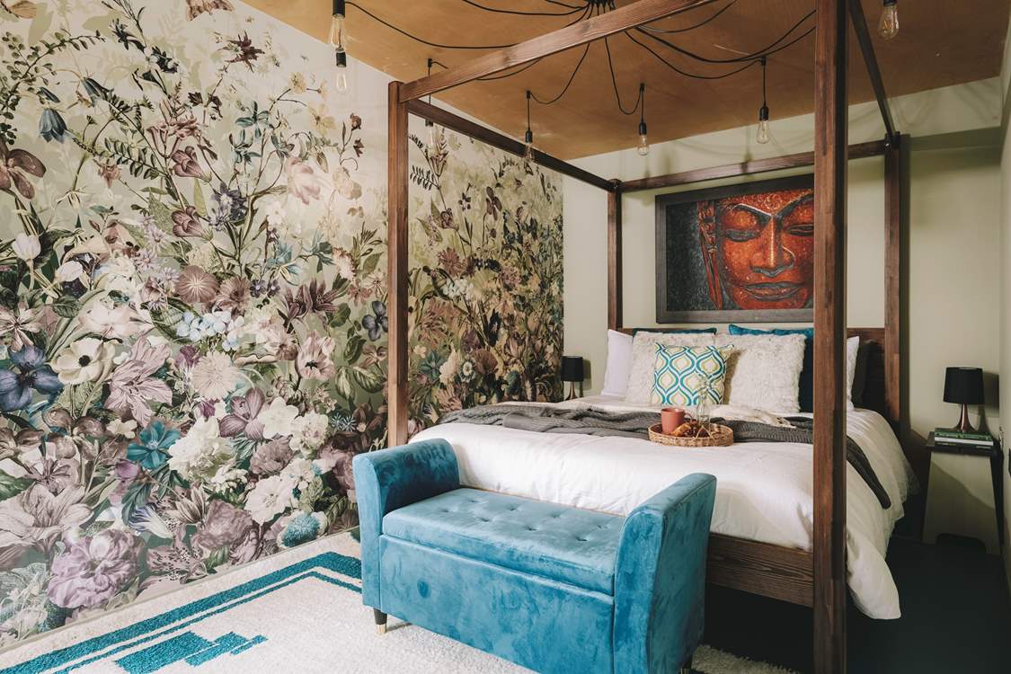 The stunning main bedroom hosts a king-size four-poster bed, adorned with luxurious soft linens.