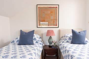 Pretty bedspreads and plump cushions adorn the beds.