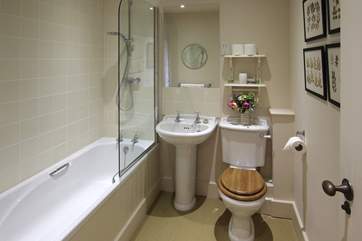 The family bathroom has a bath with shower over.