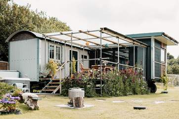 We love the unique design of this hideaway. The shepherd's hut hosts the bedroom and en suite, and the kitchen and living area are within the cabin.
