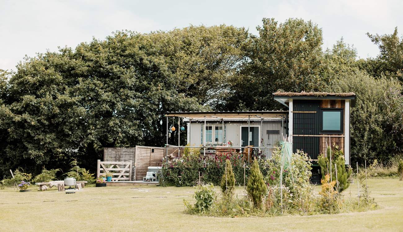 We love the unique design of this hideaway. The shepherd's hut hosts the bedroom and en suite, and the kitchen and living area are within the cabin. 