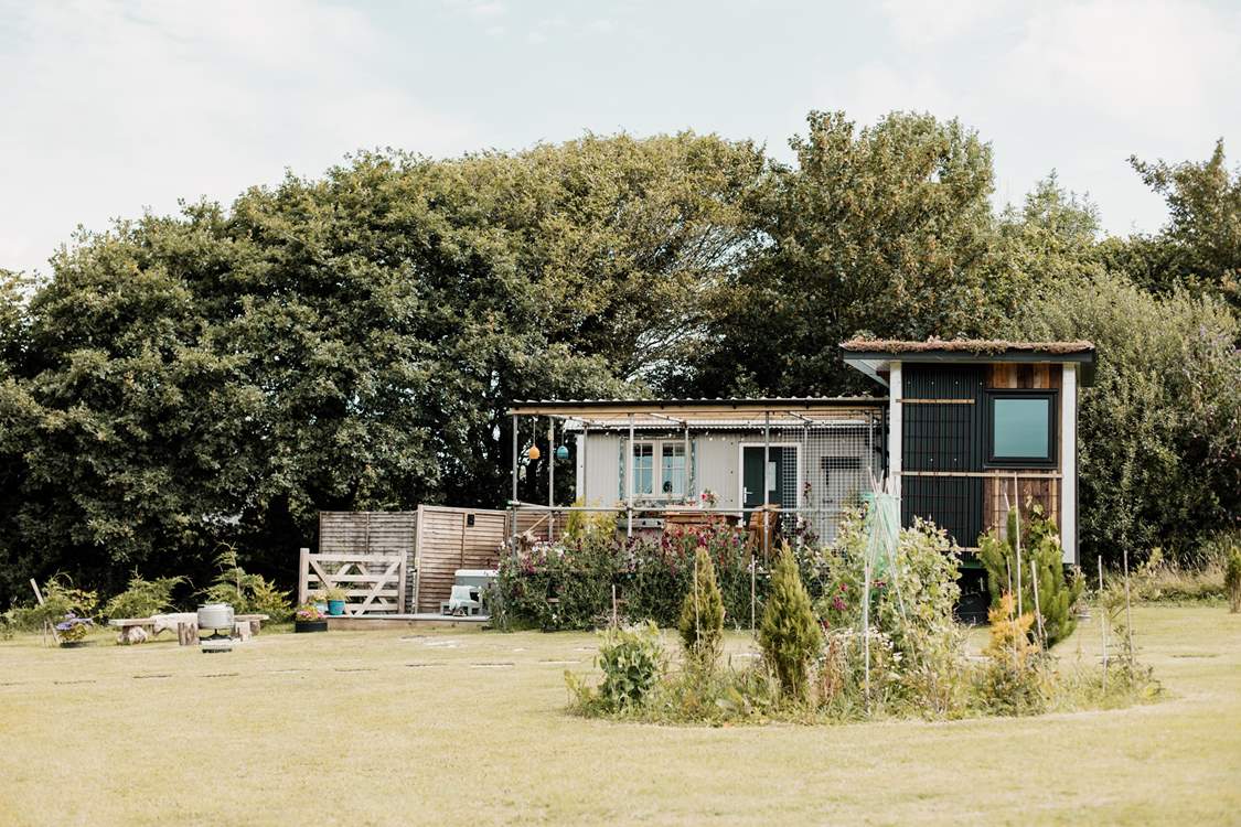 We love the unique design of this hideaway. The shepherd's hut hosts the bedroom and en suite, and the kitchen and living area are within the cabin.