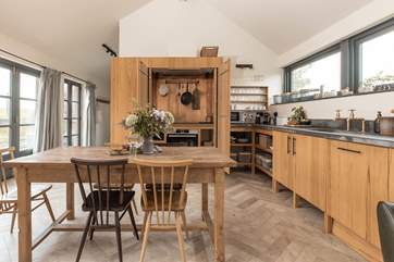The cooker and hob are cleverly tucked away behind the double doors.