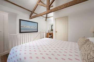The vaulted ceiling and exposed beams add to the overall charm and character of the cottage.