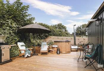 The sun soaked deck hosts a dreamy wood-fired hot tub, bistro table, wooden loungers and an impressive barbecue. 