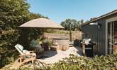 The sun soaked deck hosts a dreamy wood-fired hot tub, bistro table, wooden loungers and an impressive barbecue.  - Thumbnail Image