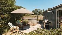 The sun soaked deck hosts a dreamy wood-fired hot tub, bistro table, wooden loungers and an impressive barbecue. 