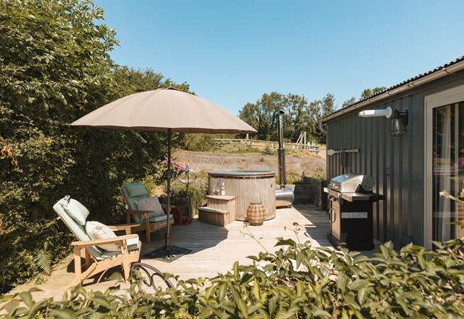 The sun soaked deck hosts a dreamy wood-fired hot tub, bistro table, wooden loungers and an impressive barbecue. 