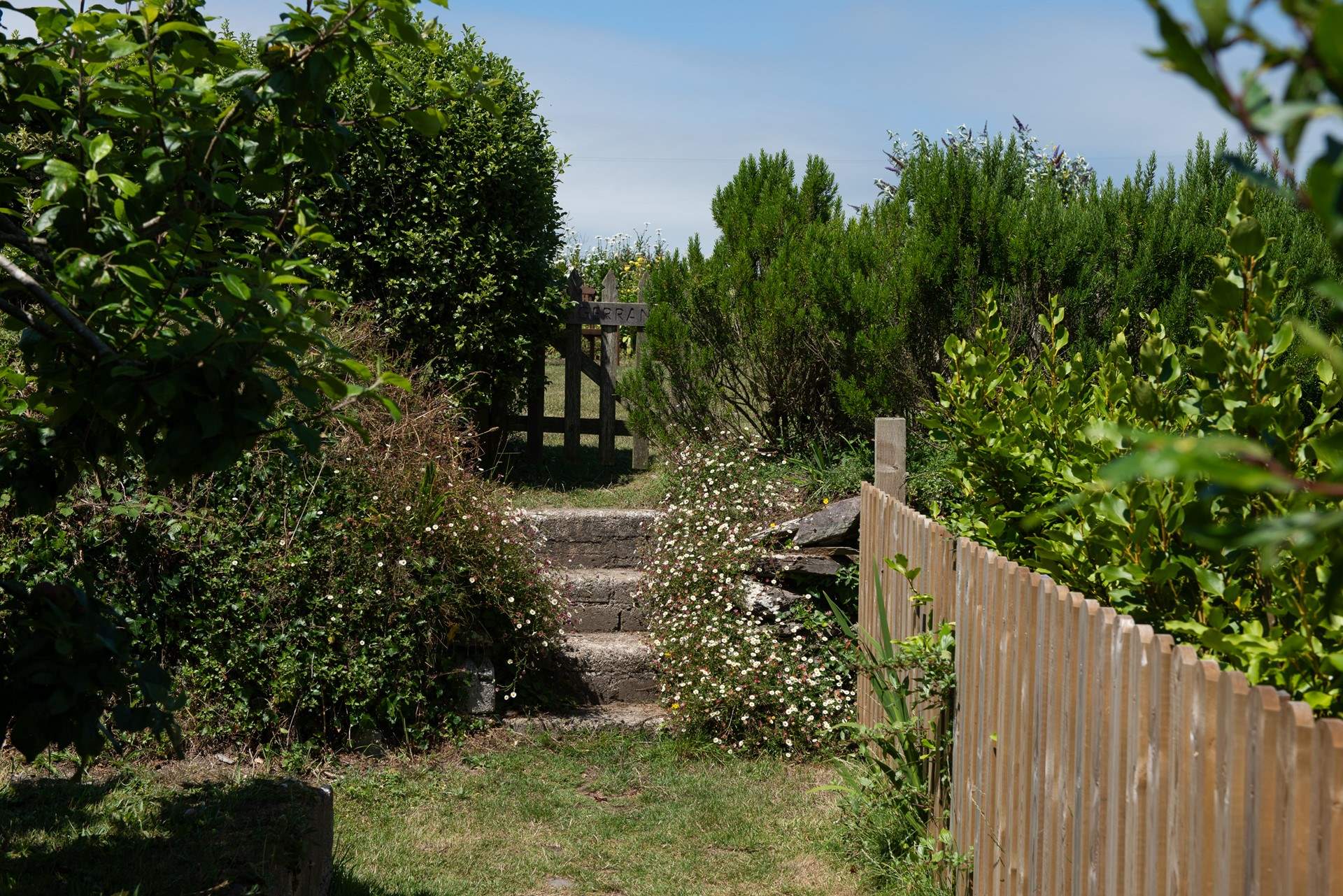Three steps up and follow the path to the left into the rear secret garden and raised deck.