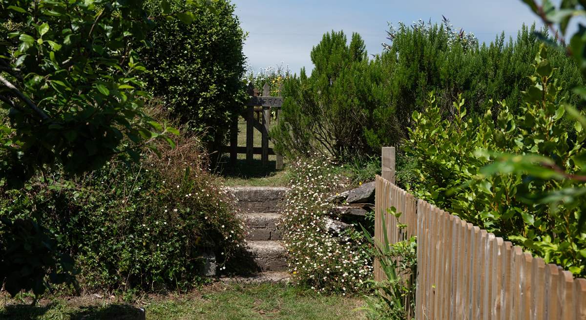 Three steps up and follow the path to the left into the rear secret garden and raised deck.