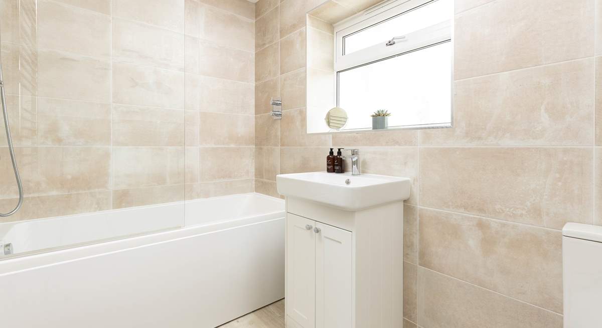 The family bathroom has a bath with shower overhead. 